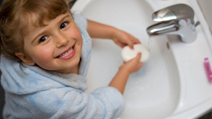 fëmija lan duart me sapun për të parandaluar krimbat